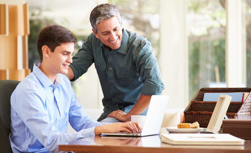 Image Showing A Father and Son Discussion About Some Topic While Seeing Their Laptop..